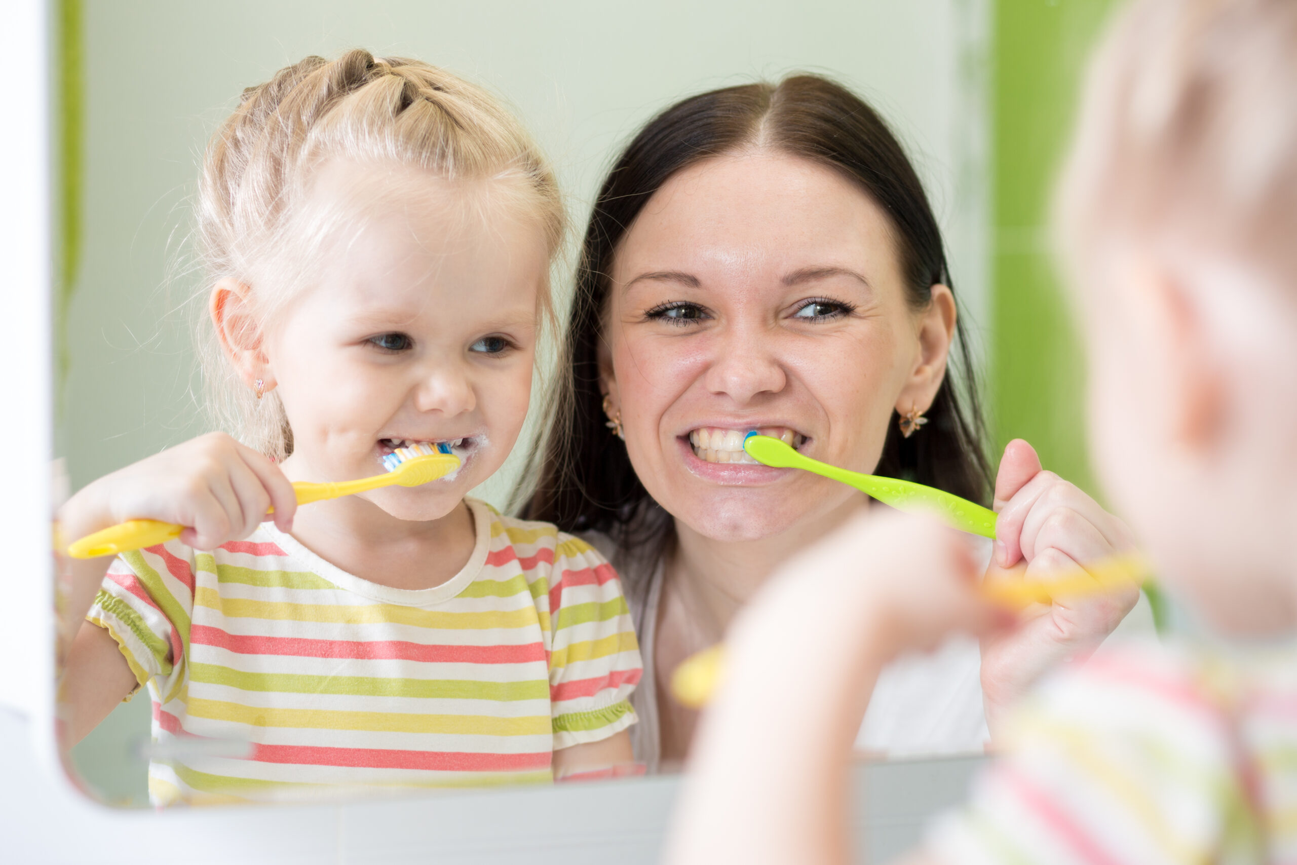 Mother And KId Daughter Brushing Teeth Together